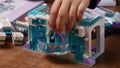 Toddler hand takes Lego princess while playing Lego blocks of Frozen Disney cartoon