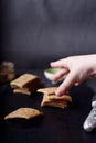 Kids hand taking homemade whole wheat crackers on dark background Royalty Free Stock Photo