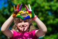 Kids hands in color paints make a heart shape, focus on hands