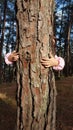 Kids hands hugging tree trunk Royalty Free Stock Photo