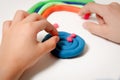 Child hands molding modeling clay or plasticine on white table Royalty Free Stock Photo