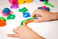 Child hands molding modeling clay or plasticine on white table Royalty Free Stock Photo