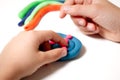 Child hands molding modeling clay or plasticine on white table Royalty Free Stock Photo