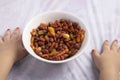 Kids hands neaer plate with boiled red beans with parsley in white bowl closeup on the table Royalty Free Stock Photo