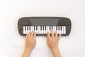 Kids hands play on piano keys, toy synthesizer on white background. Children`s skills of playing musical instruments. Musical Royalty Free Stock Photo