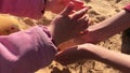 Kids hands play in sand, palms pouring wash to cup hands