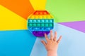 kids hands push sensory popit on colorfull background.