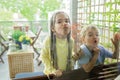 Kids have fun and lean against window glass with faces on balcony at home. Terrace life on vacation