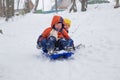 Kids have fun sledding with snow slides Royalty Free Stock Photo