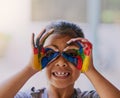 Kids have the most creative ways of viewing the world. Portrait of a little girl with her hands covered in paint. Royalty Free Stock Photo