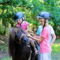 Kids having fun at horse riding summer camp Royalty Free Stock Photo