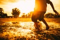 Kids are playing soccer football for exercise under the sunlight. Silhouette and film picture style. Royalty Free Stock Photo