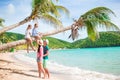 Kids having fun sitting on the palm tree. Happy family relaxing on tropical Carlisle bay beach with white sand and Royalty Free Stock Photo