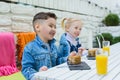 Kids having healthy breakfast. children drinking juice and eating pie Royalty Free Stock Photo