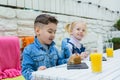 Kids having healthy breakfast. children drinking juice and eating pie Royalty Free Stock Photo