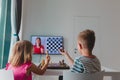 Kids having online chess lesson, e-education, boy and girl on distance learning