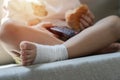 Kids healthcare and medicine concept - little child boy siting on sofa with plaster bandage on leg Royalty Free Stock Photo