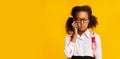 Offended Black Schoolgirl Calling To Helpline Standing Over Yellow Background