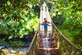 Kids hiking in the mountains. Bridge over river