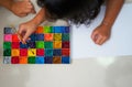 Kids hold brush and plain paper with square color palette for art work,top view