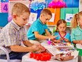 Kids holding colored paper and glue on table in Royalty Free Stock Photo