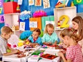 Kids holding colored paper and glue on table in Royalty Free Stock Photo