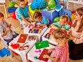 Kids holding colored paper and glue on table in Royalty Free Stock Photo