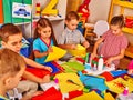 Kids holding colored paper on table in kindergarten . Royalty Free Stock Photo