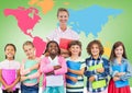Kids holding school books with teacher in front of colorful world map Royalty Free Stock Photo