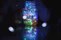 Kids holds Christmas lantern in hands on lights bokeh background. New year celebration concept