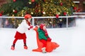 Kids ice skating in winter park rink. Children ice skate on Christmas fair. Little girl and boy with skates on cold day. Snow Royalty Free Stock Photo