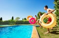 Kids with inflatable buoys run dive into the pool Royalty Free Stock Photo