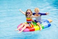 Kids on inflatable float in swimming pool. Royalty Free Stock Photo