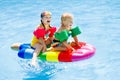 Kids on inflatable float in swimming pool. Royalty Free Stock Photo