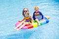 Kids on inflatable float in swimming pool. Royalty Free Stock Photo