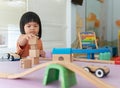 Kids intend learn from play with colorful wooden toy on table desk at home. Preschool young girl concentrating with educational bl Royalty Free Stock Photo