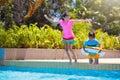 Kids jump into swimming pool. Summer water fun Royalty Free Stock Photo