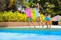 Kids jump into swimming pool. Summer water fun Royalty Free Stock Photo