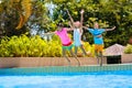 Kids jump into swimming pool. Summer water fun Royalty Free Stock Photo