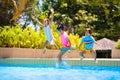 Kids jump into swimming pool. Summer water fun Royalty Free Stock Photo