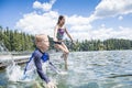 Kids jumping off the dock into a beautiful mountain lake. Having fun on a summer vacation Royalty Free Stock Photo