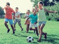 Kids kicking football in park Royalty Free Stock Photo