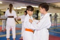 Kids in kimonos exercising techniques in pair during taekwondo class at gym closeup
