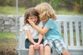 Kids kissing in summer park outdoors. Little boy and girl kids enjoying summer. Best friends two children.