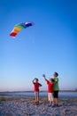 Kids launching the rainbow kite together Royalty Free Stock Photo