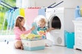 Kids in laundry room with washing machine Royalty Free Stock Photo