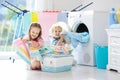 Kids in laundry room with washing machine Royalty Free Stock Photo