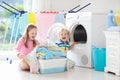 Kids in laundry room with washing machine Royalty Free Stock Photo