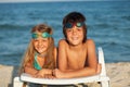 Kids laying on beach chair wearing swimming goggles Royalty Free Stock Photo