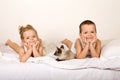 Kids laying in the bed with their kitten Royalty Free Stock Photo